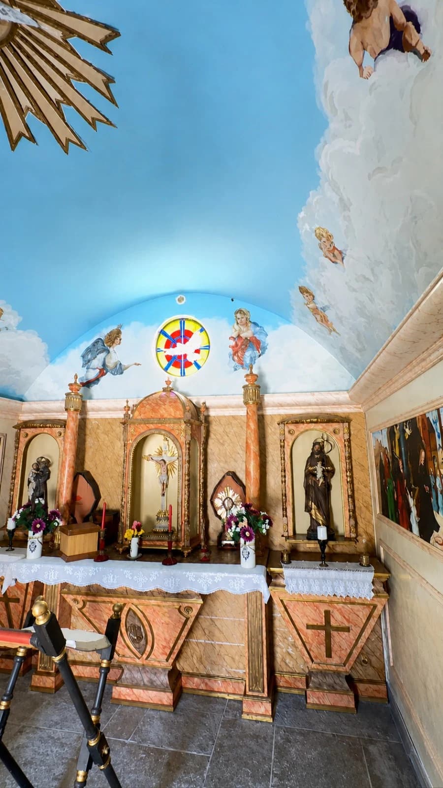 Vista frontal do altar principal, do vitral e dos frescos da capela